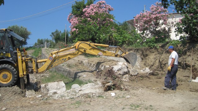 wall being cleared of remaining trees and dirt